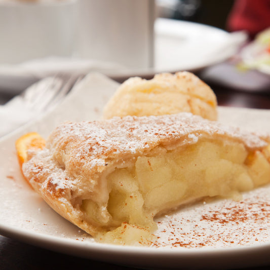 A slice of apple pie on a serving dish