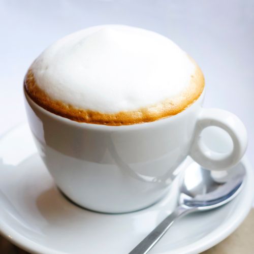 A serving cup of Cappuccino Captain Coffee with spoon