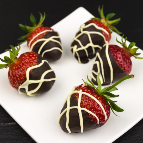 Chocolate-covered strawberries on a square white dessert dish