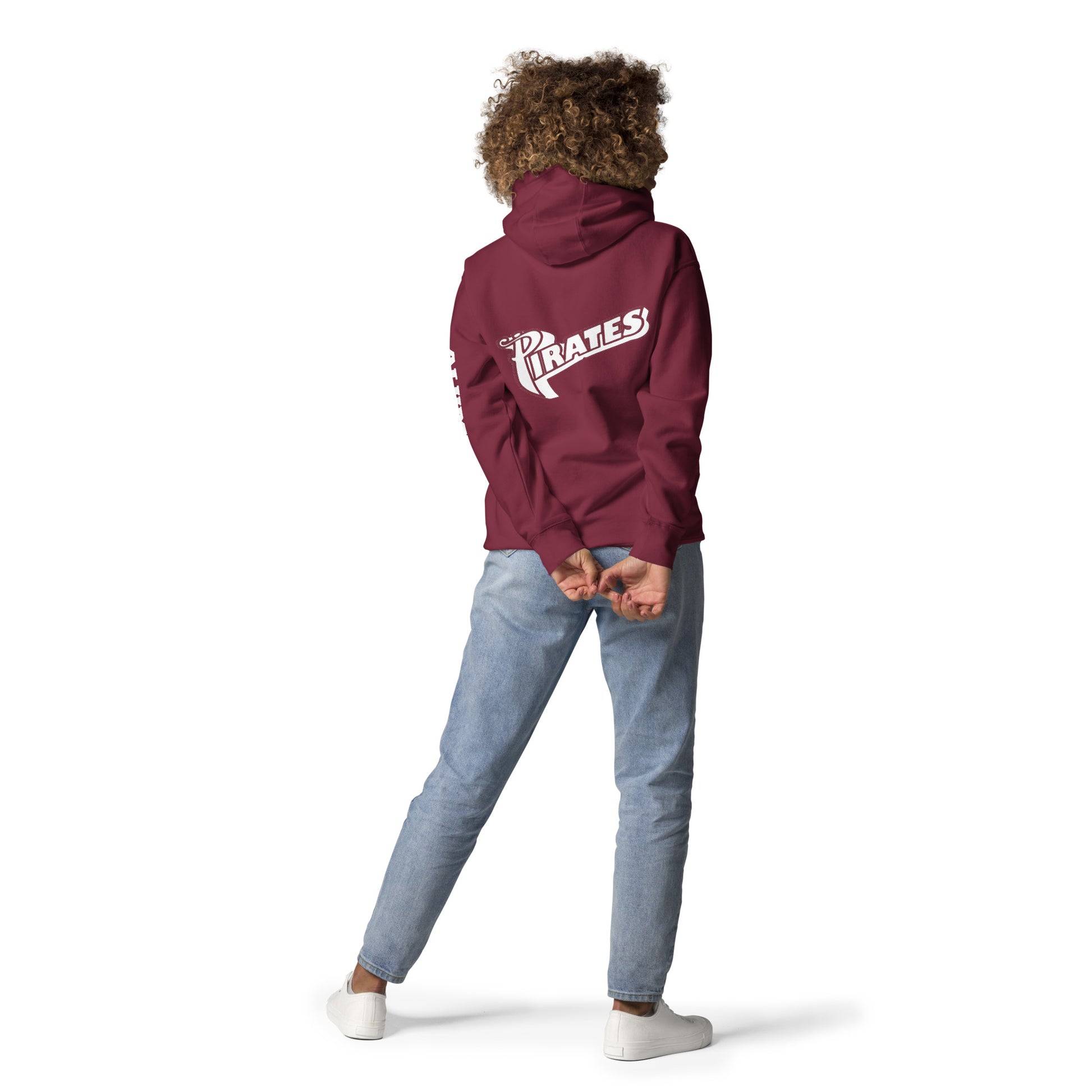 A lady holding standing with her hands touching and wearing a maroon Saint Jude High School Hoodie with her back facing the camera showing the word, "Pirates"